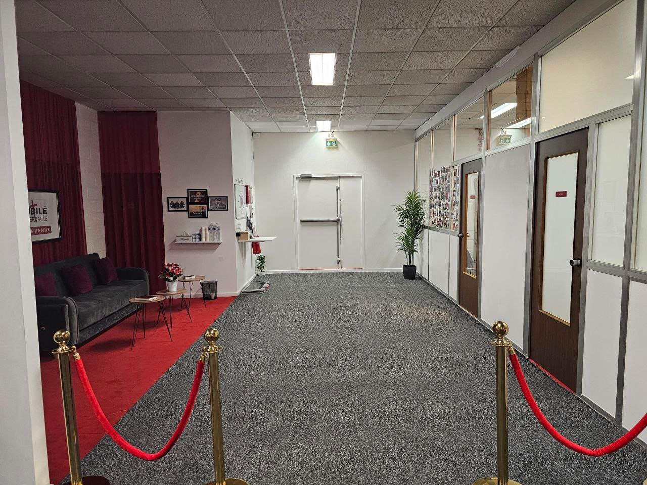 Le hall d'entrée qui mène à la salle de culte, avec la croix au mur